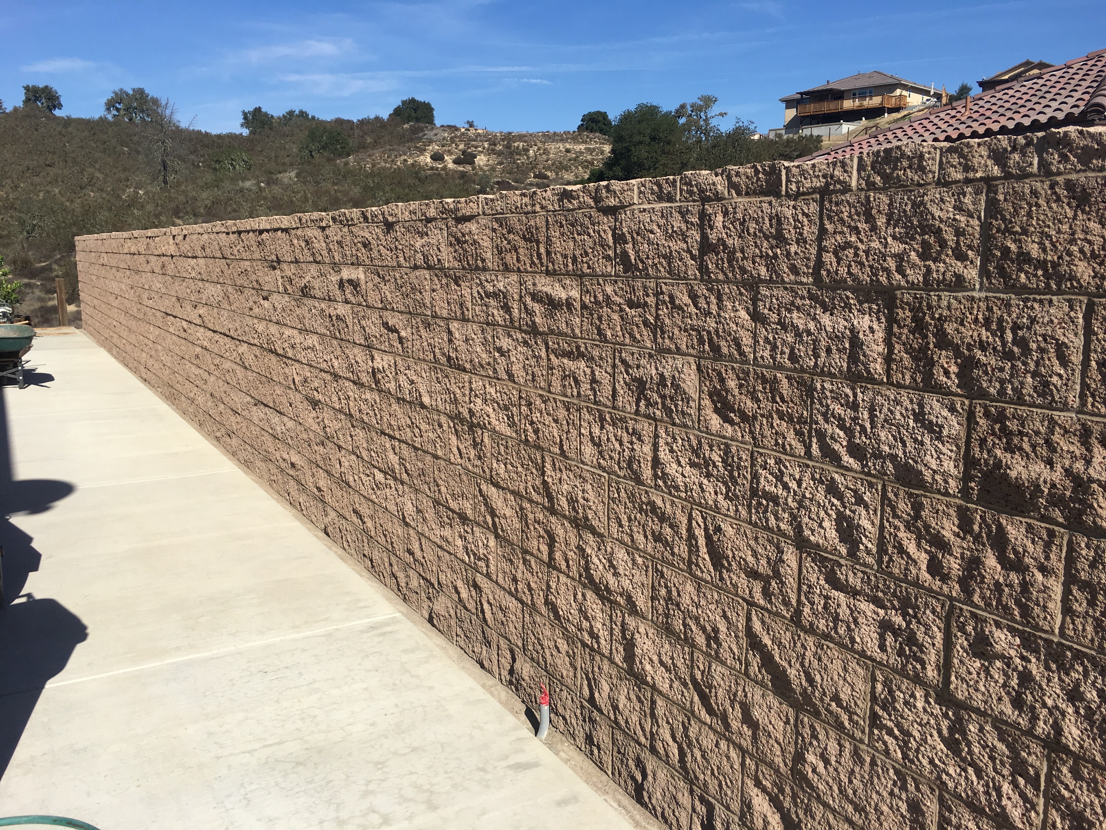Large residential retaining wall with concrete block construction by Capps Construction